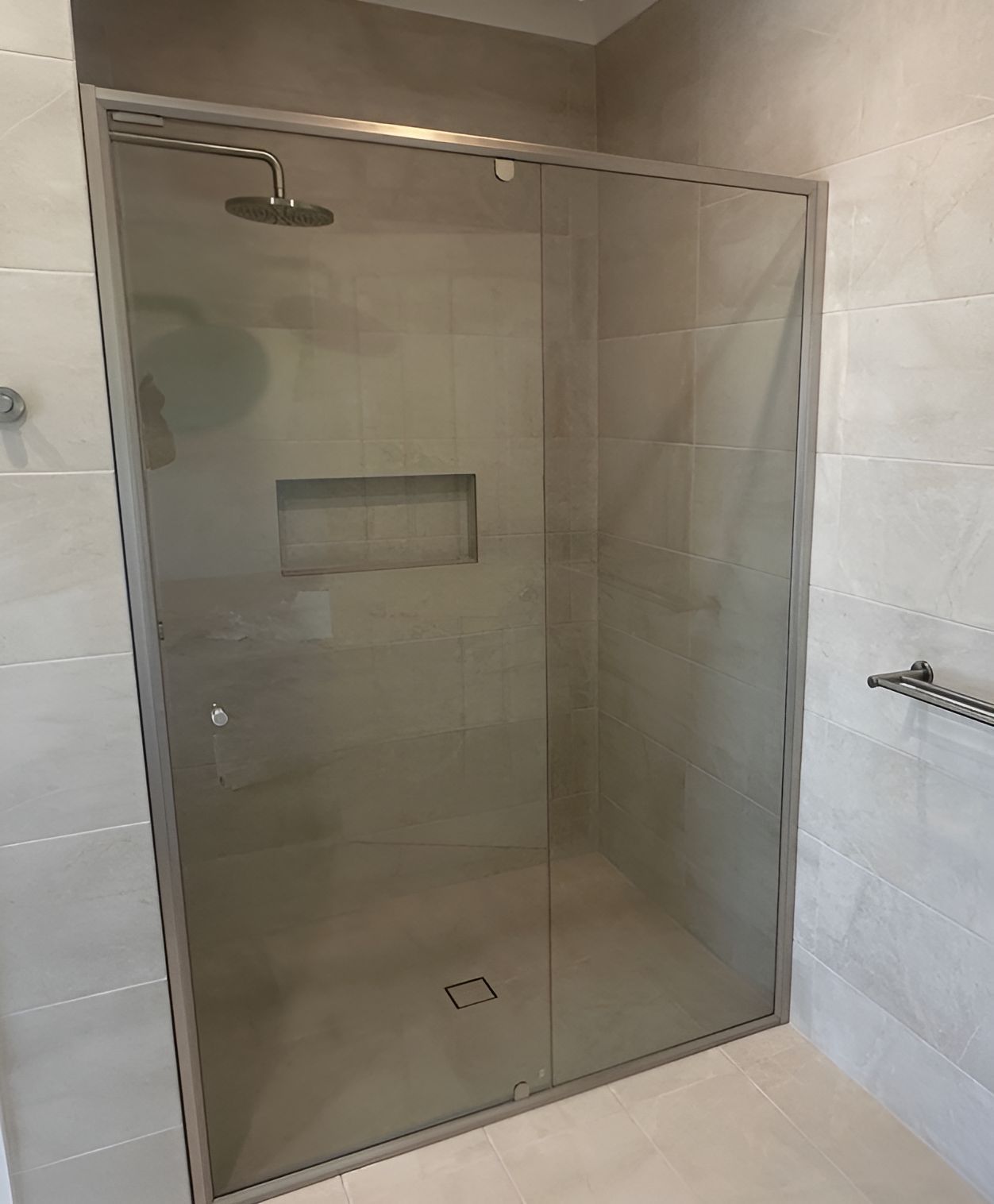 A Bathroom With a Sliding Glass Shower Door and a Shower Head — Canobolas Glass Service In Orange, NSW