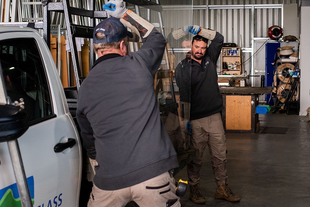 Two Men Are Working on a Glass Van in a Garage — Canobolas Glass Service In Orange, NSW