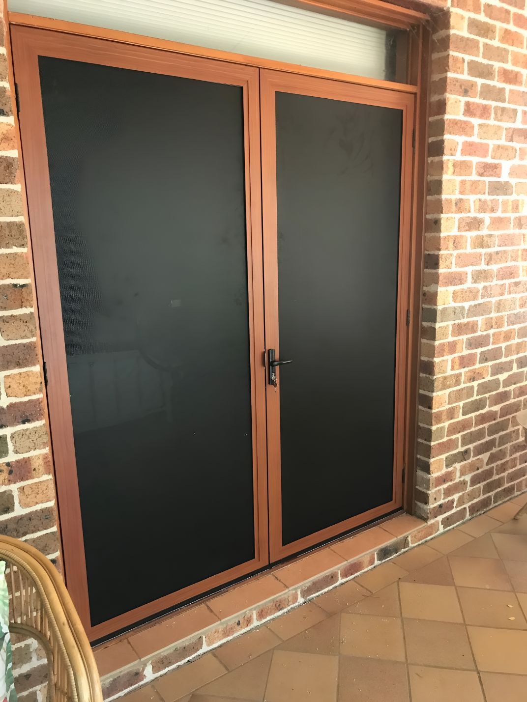 A Pair of Sliding Glass Doors With Black Screens on a Brick Wall — Canobolas Glass Service In Orange, NSW