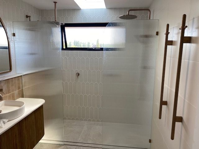 A Bathroom With a Walk in Shower , Sink and Mirror — Canobolas Glass Service In Orange, NSW