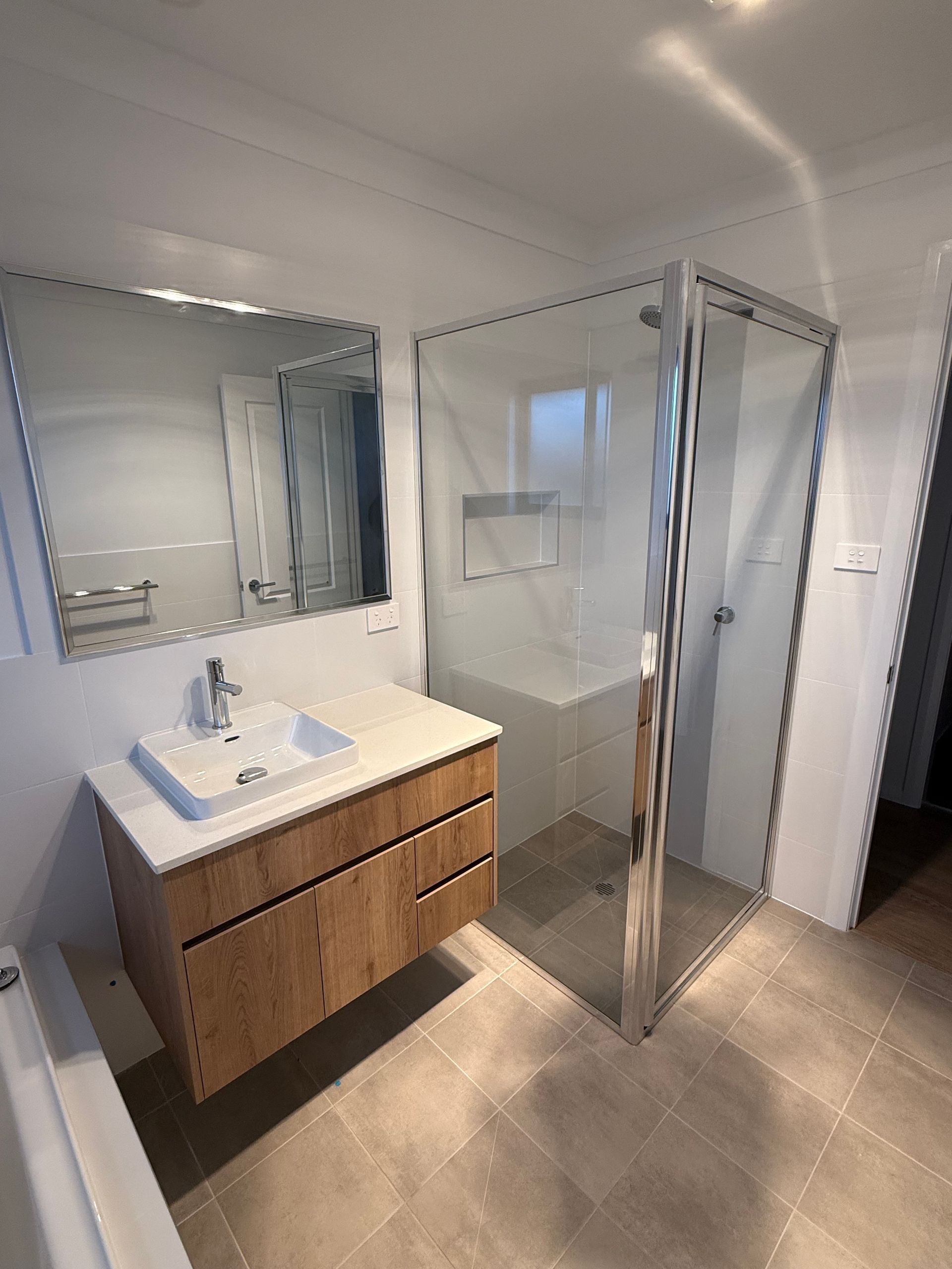 A Bathroom With a Shower , Sink and Mirror — Canobolas Glass Service In Orange, NSW
