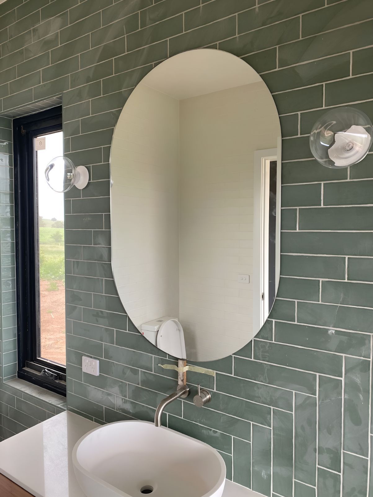 Oval Mirror Hanging In Bathroom — Canobolas Glass Service In Orange, NSW