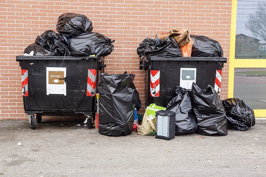 two dumpsters with black bags