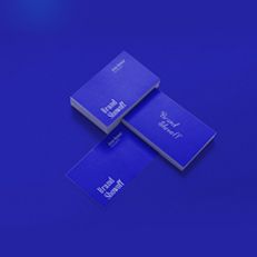 Two blue business cards are stacked on top of each other on a blue surface.