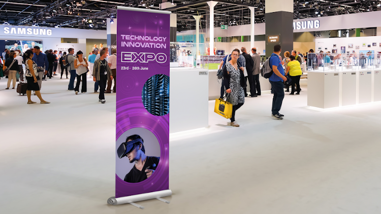 A group of people are standing in a room at an expo.