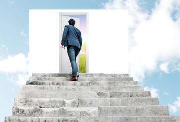 A man is walking up a set of stairs towards a door.