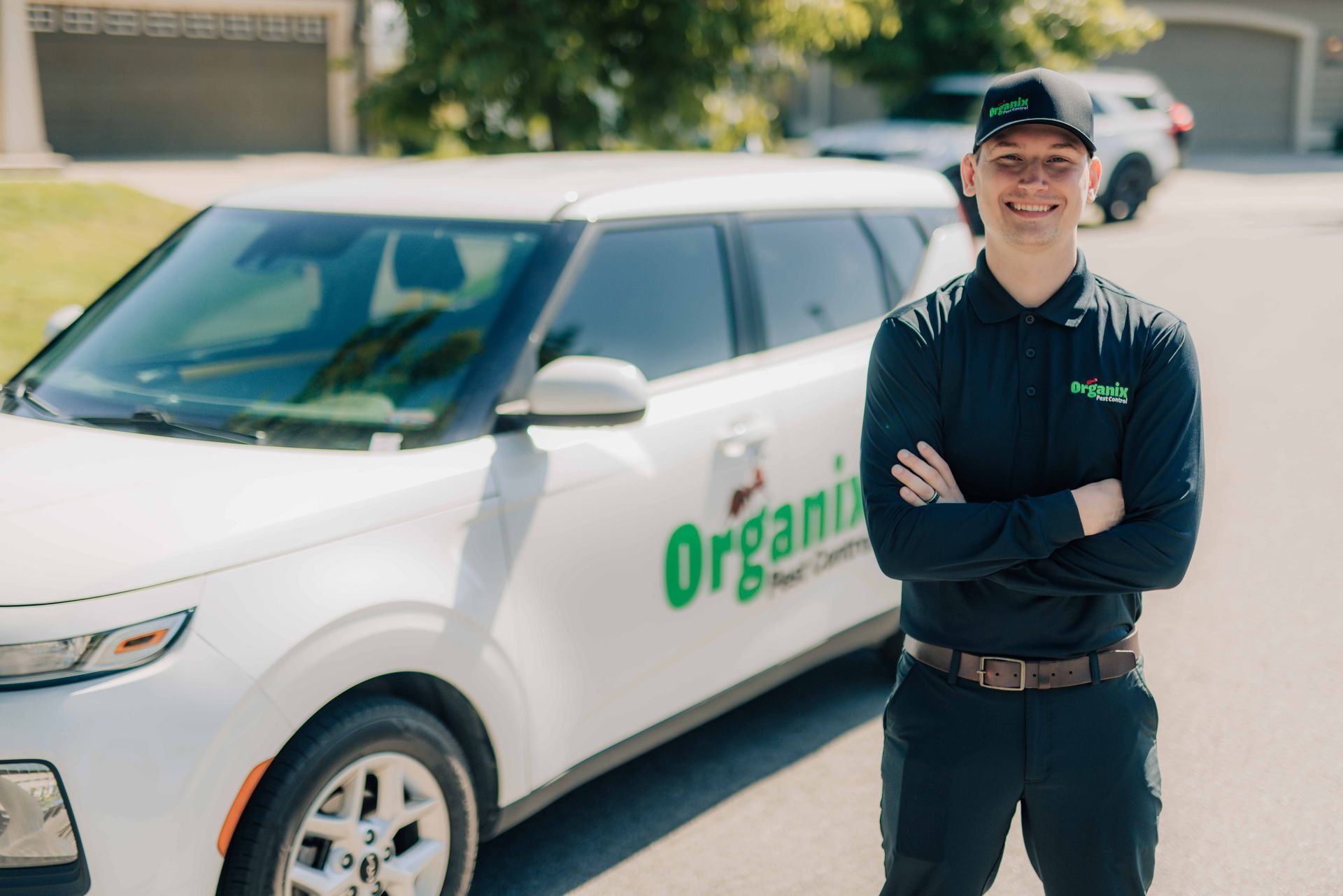 A man wearing a green organics hat and a white shirt