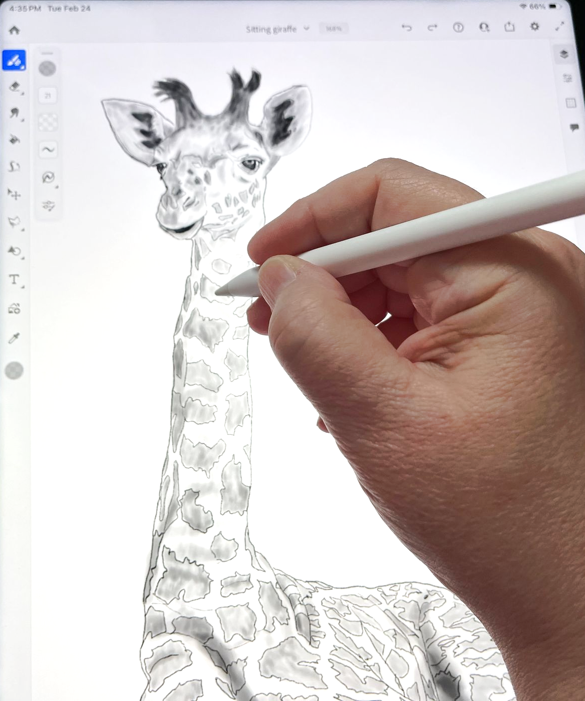 A hand uses a digital stylus to sketch a giraffe on a tablet screen.