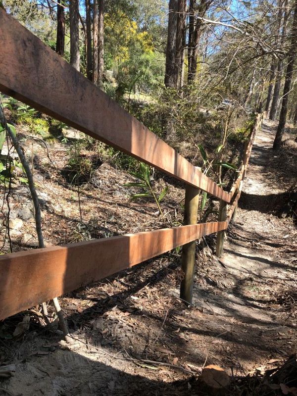 A Wooden Fence Along a Path in the Woods — Aztech Fencing In Taree, NSW