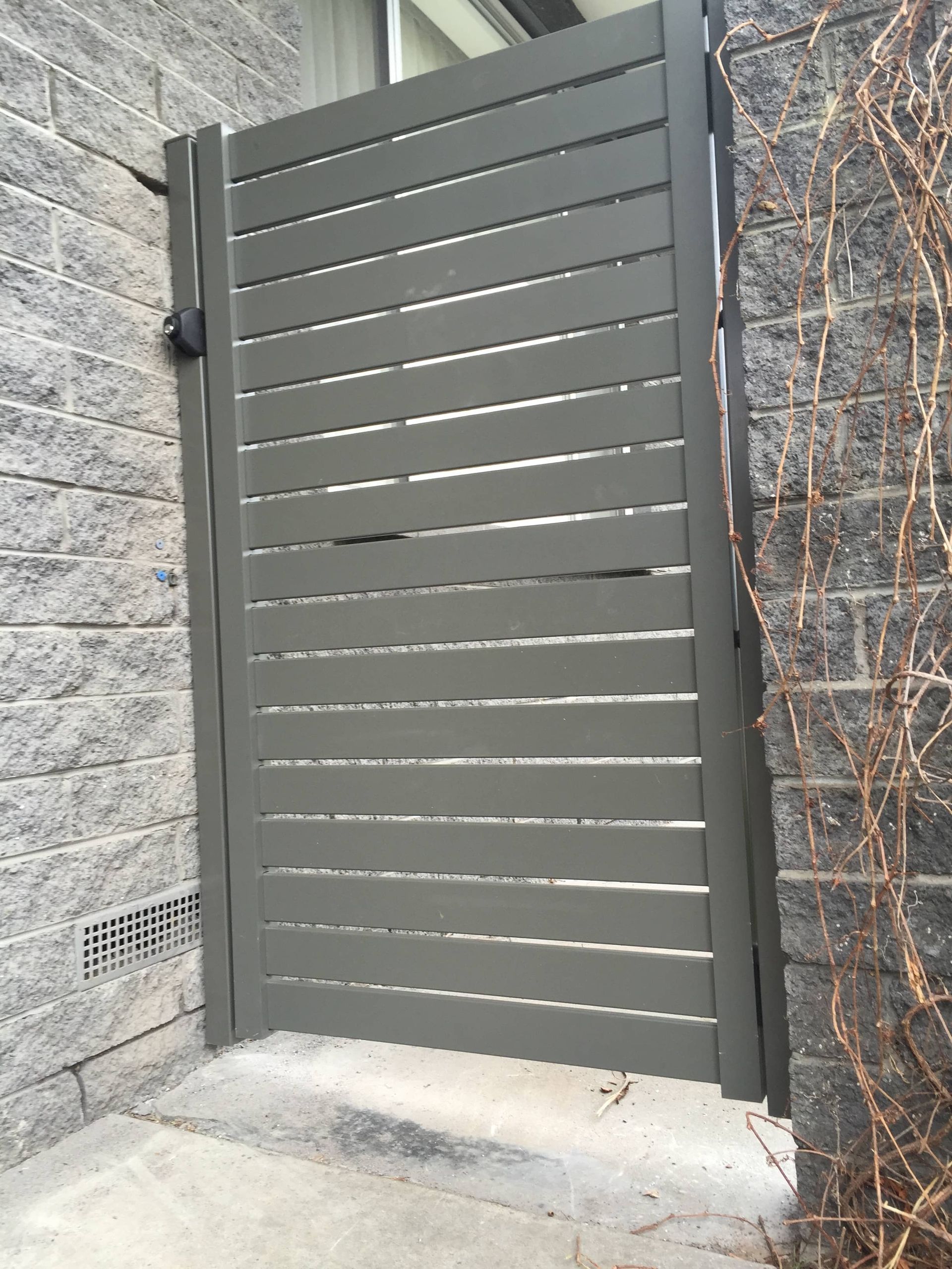 A gray gate is sitting next to a brick wall — Aztech Fencing In Upsalls Creek, NSW