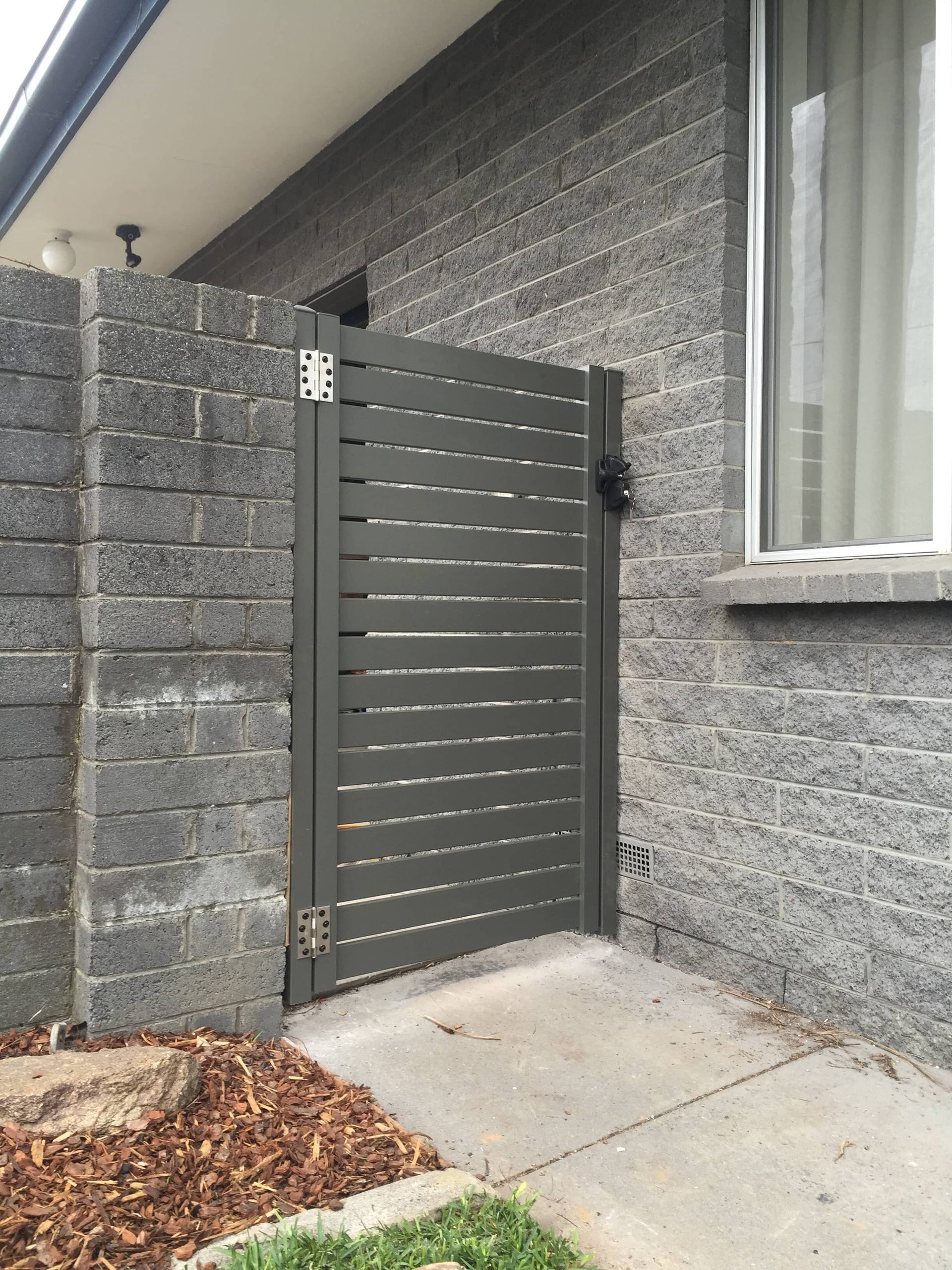A brick wall with a gate in front of it — Aztech Fencing In Upsalls Creek, NSW