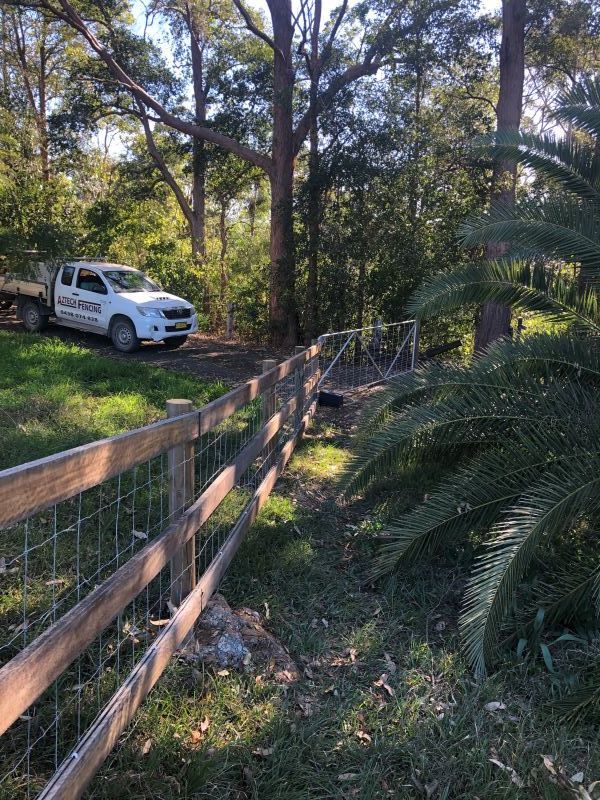 A White Truck is Parked Next to a Wooden Fence — Aztech Fencing In Wauchope, NSW