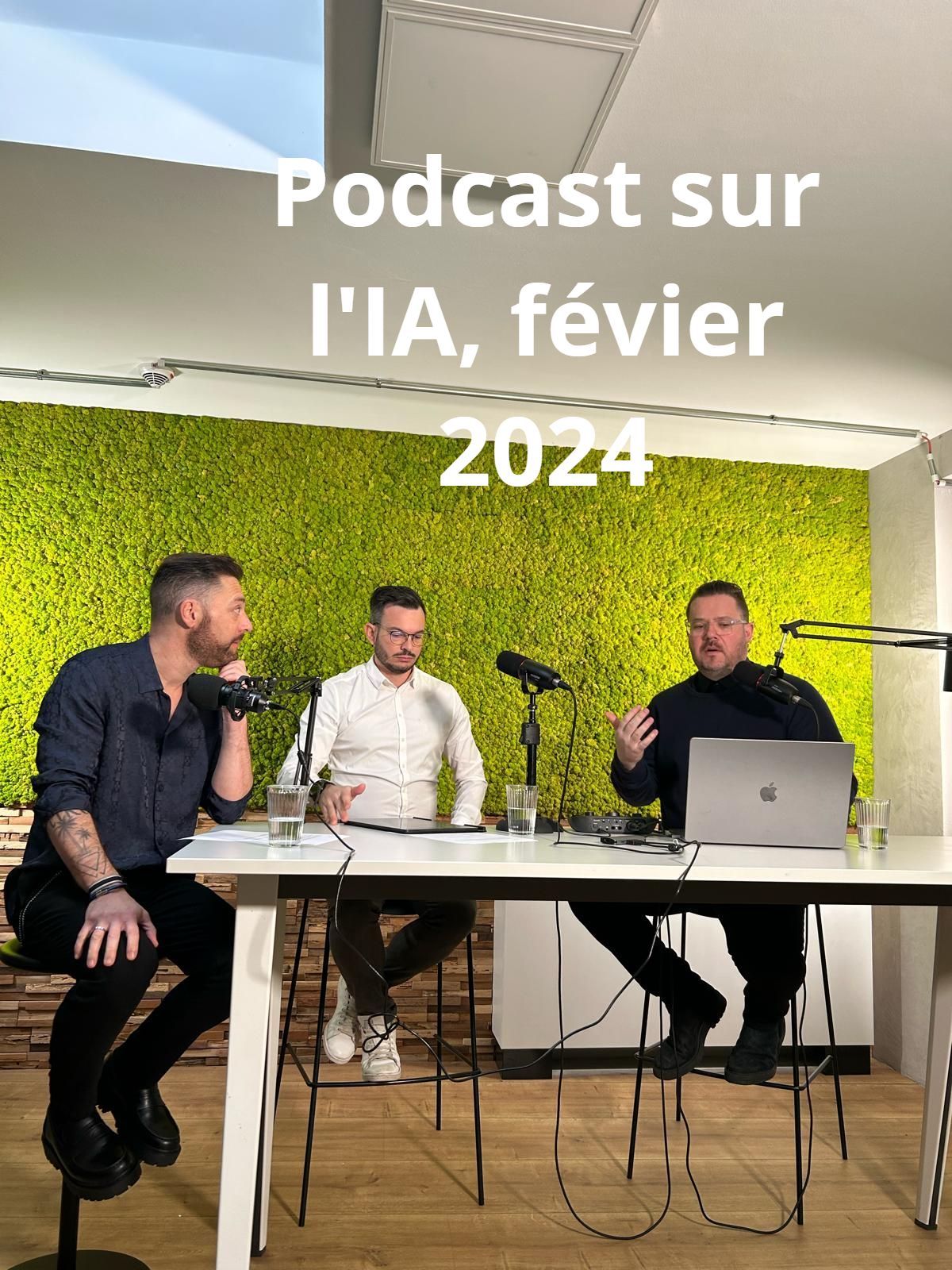 Trois hommes à une table, podcastant sur l'IA en février 2024. L'un fait des gestes, d'autres écoutent, avec un mur de mousse en arrière-plan.