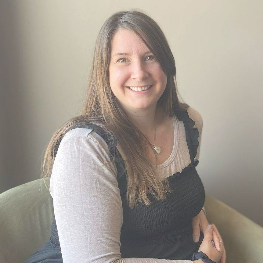 A woman is sitting in a chair and smiling for the camera