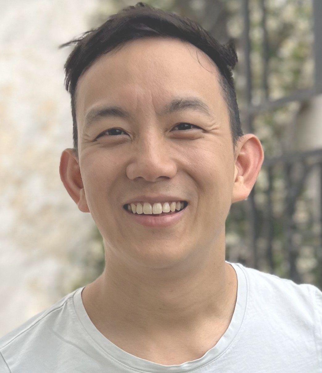A man in a blue striped shirt is smiling for the camera