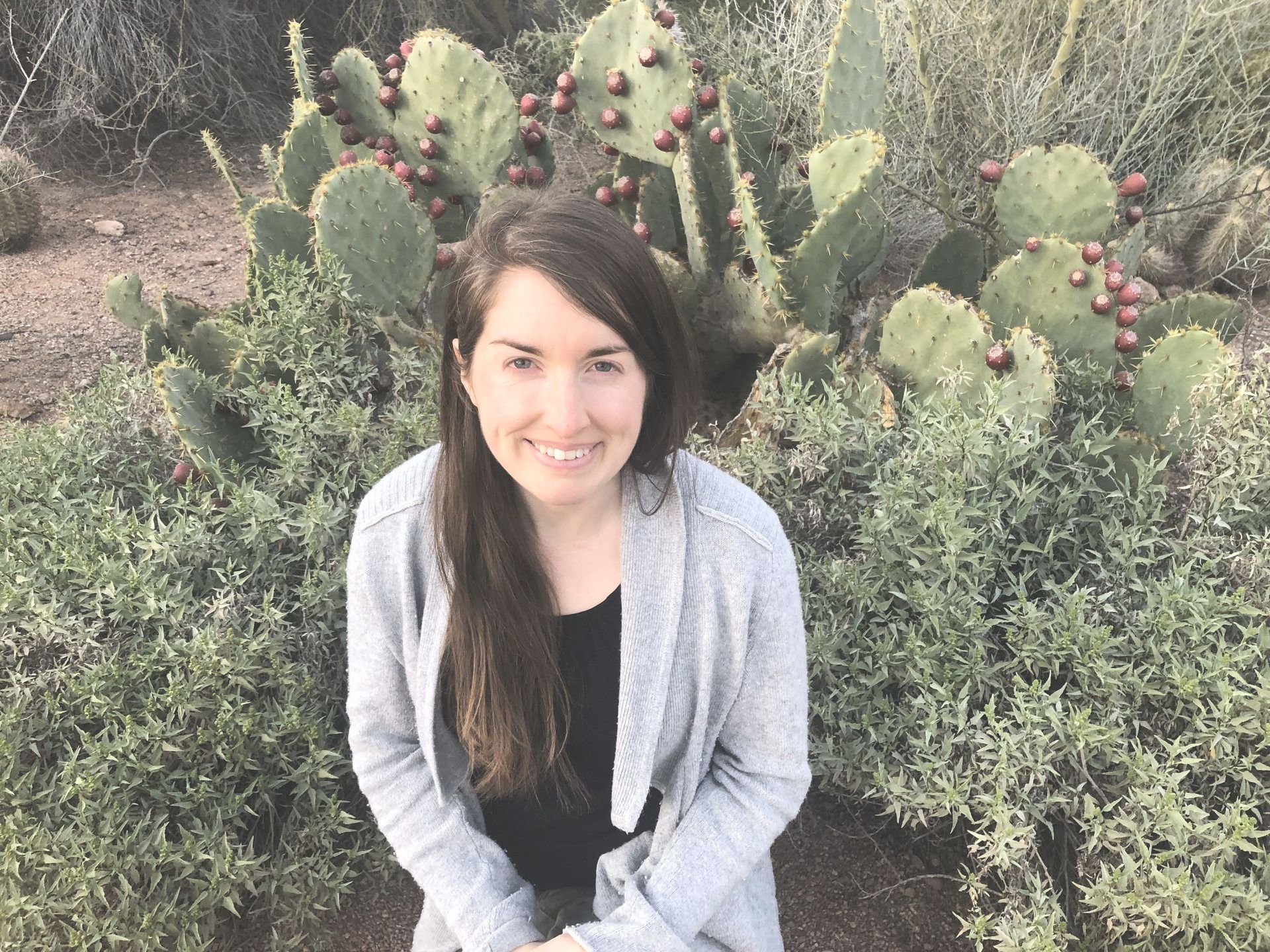 A woman in a blue dress is standing in front of a white background.