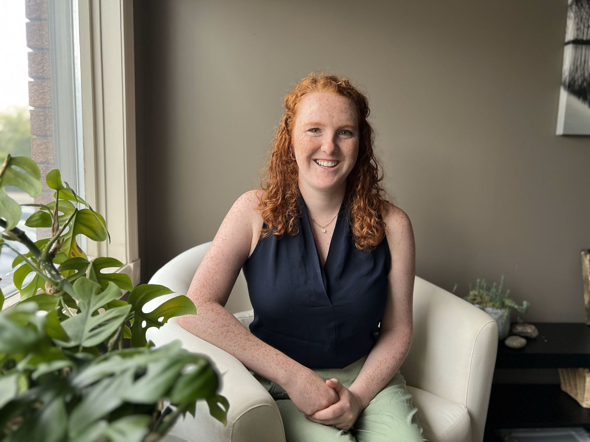 A woman in a blue shirt is smiling for the camera.