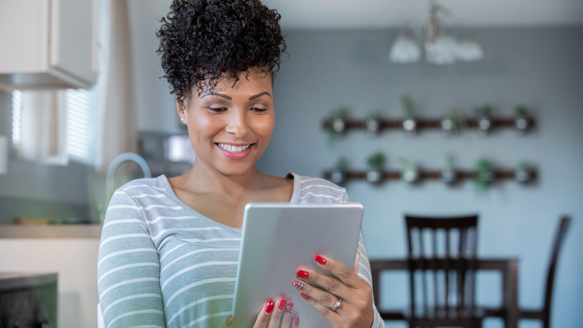 A woman is using a tablet computer in a kitchen.