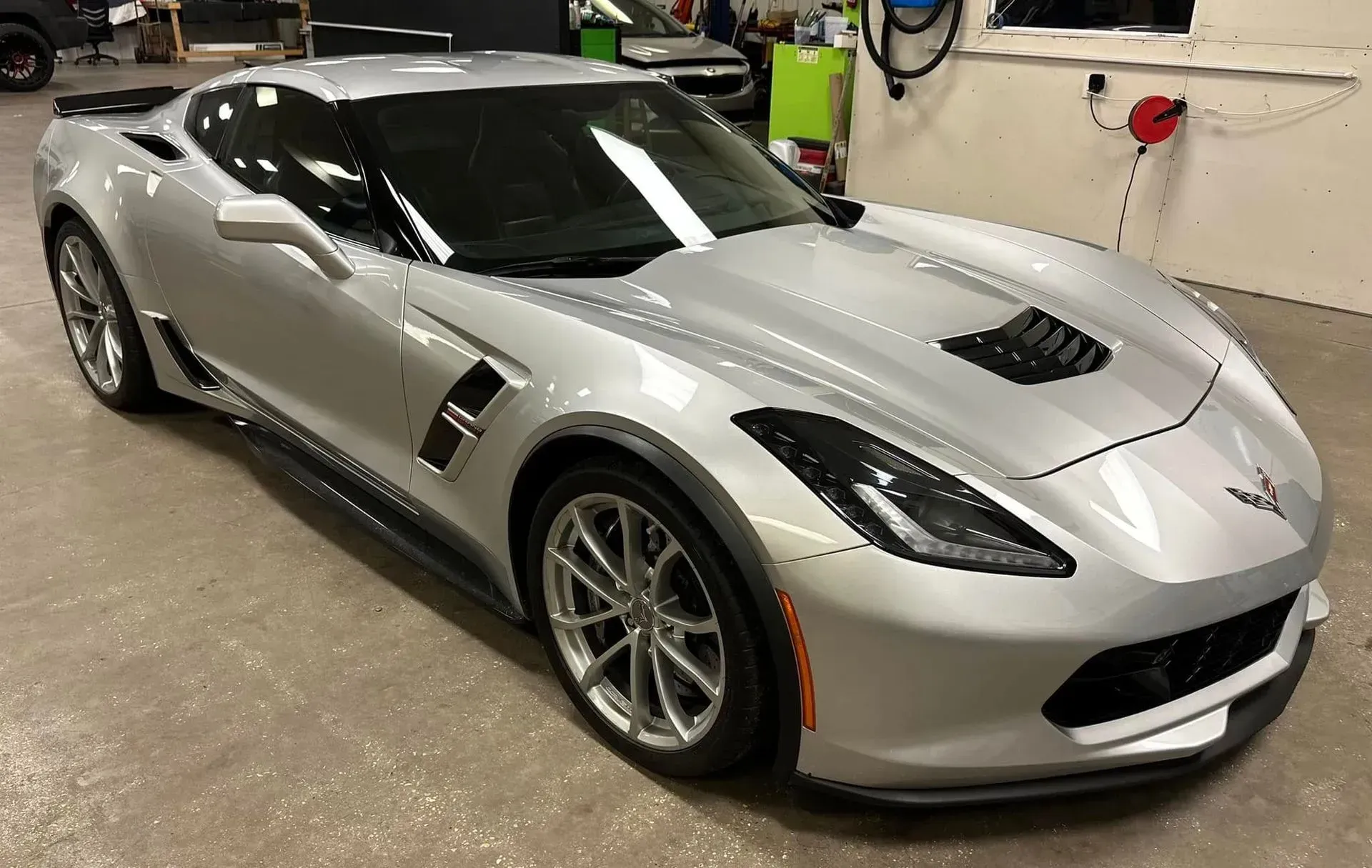 A silver corvette zr1 is parked in a garage.