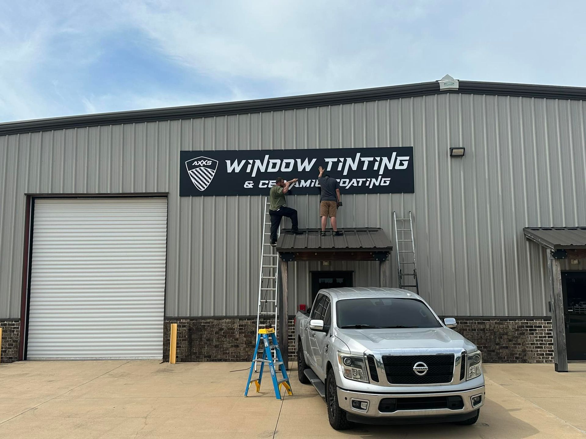 A truck is parked in front of a building that says window tinting.