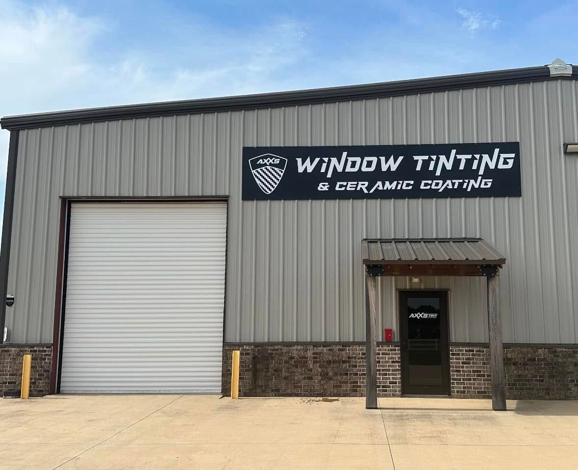 A building with a sign that says window tinting and ceramic coatings.