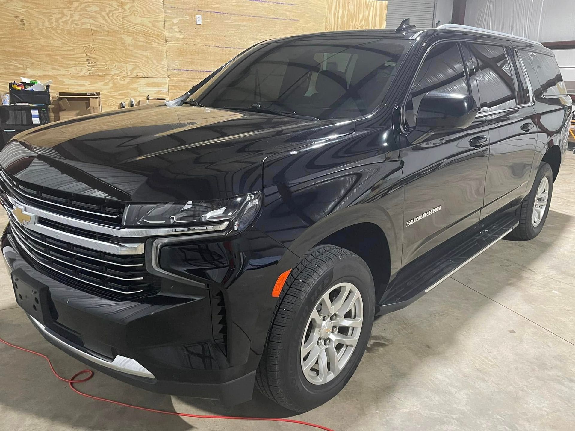 A black chevrolet suburban suv is parked in a garage.