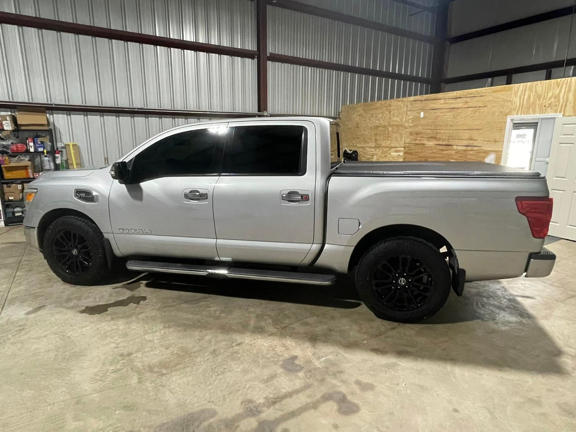A silver pickup truck is parked in a garage.