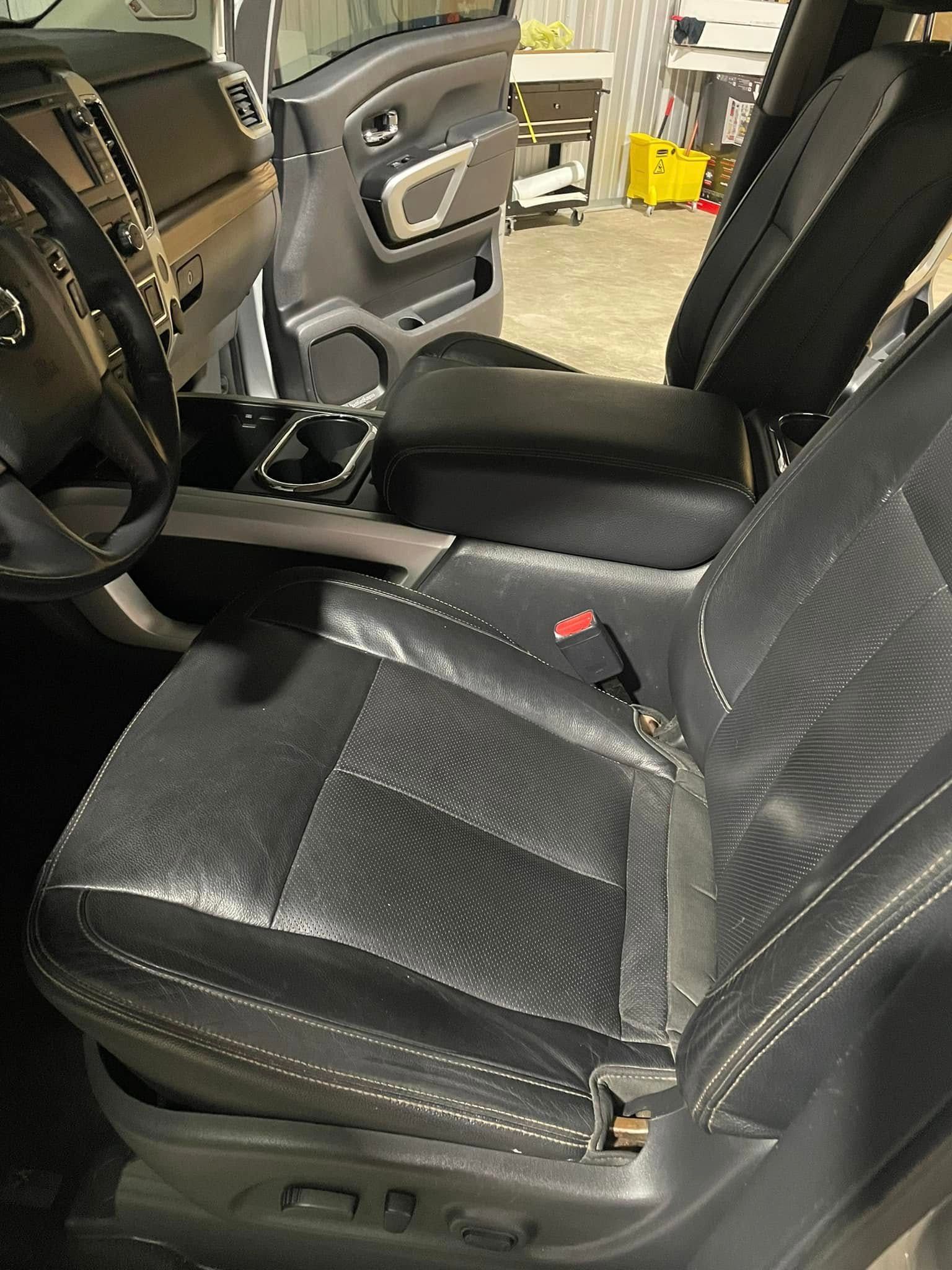 The interior of a car with black leather seats and a steering wheel.