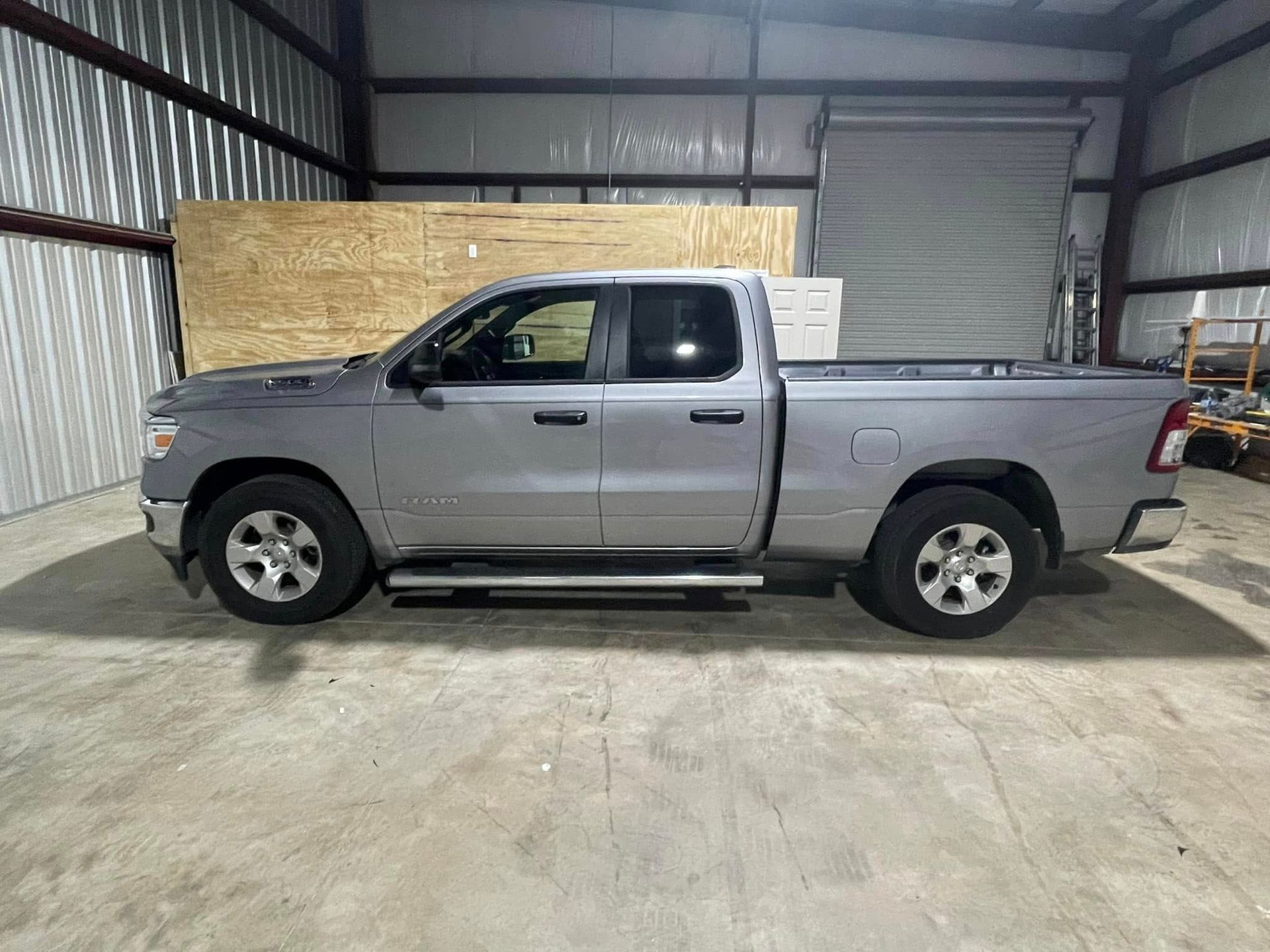 A silver pickup truck is parked in a garage.
