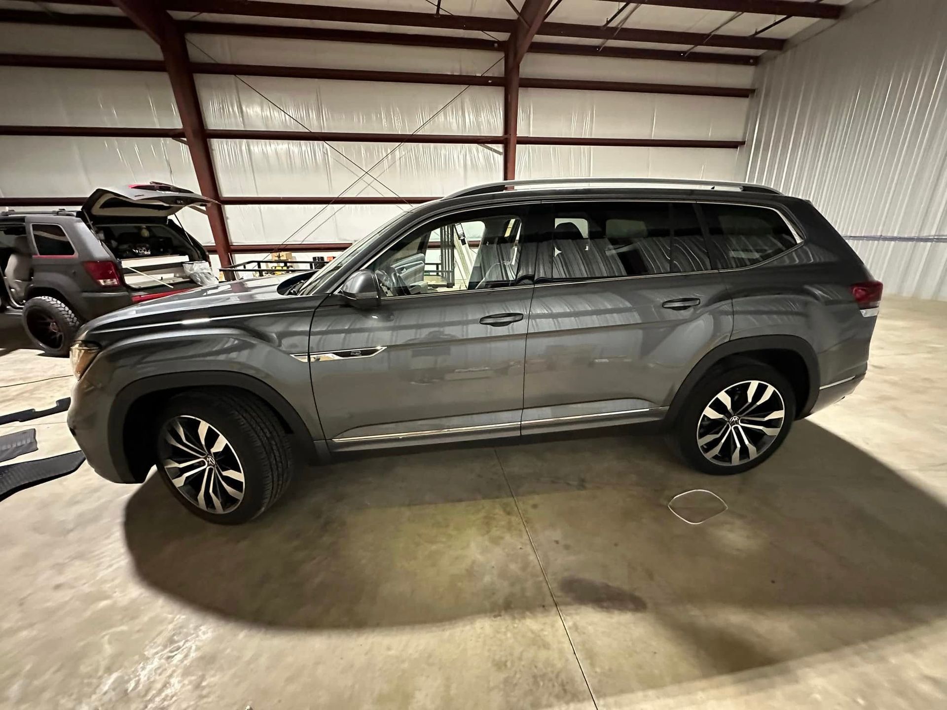 A volkswagen atlas is parked in a warehouse.