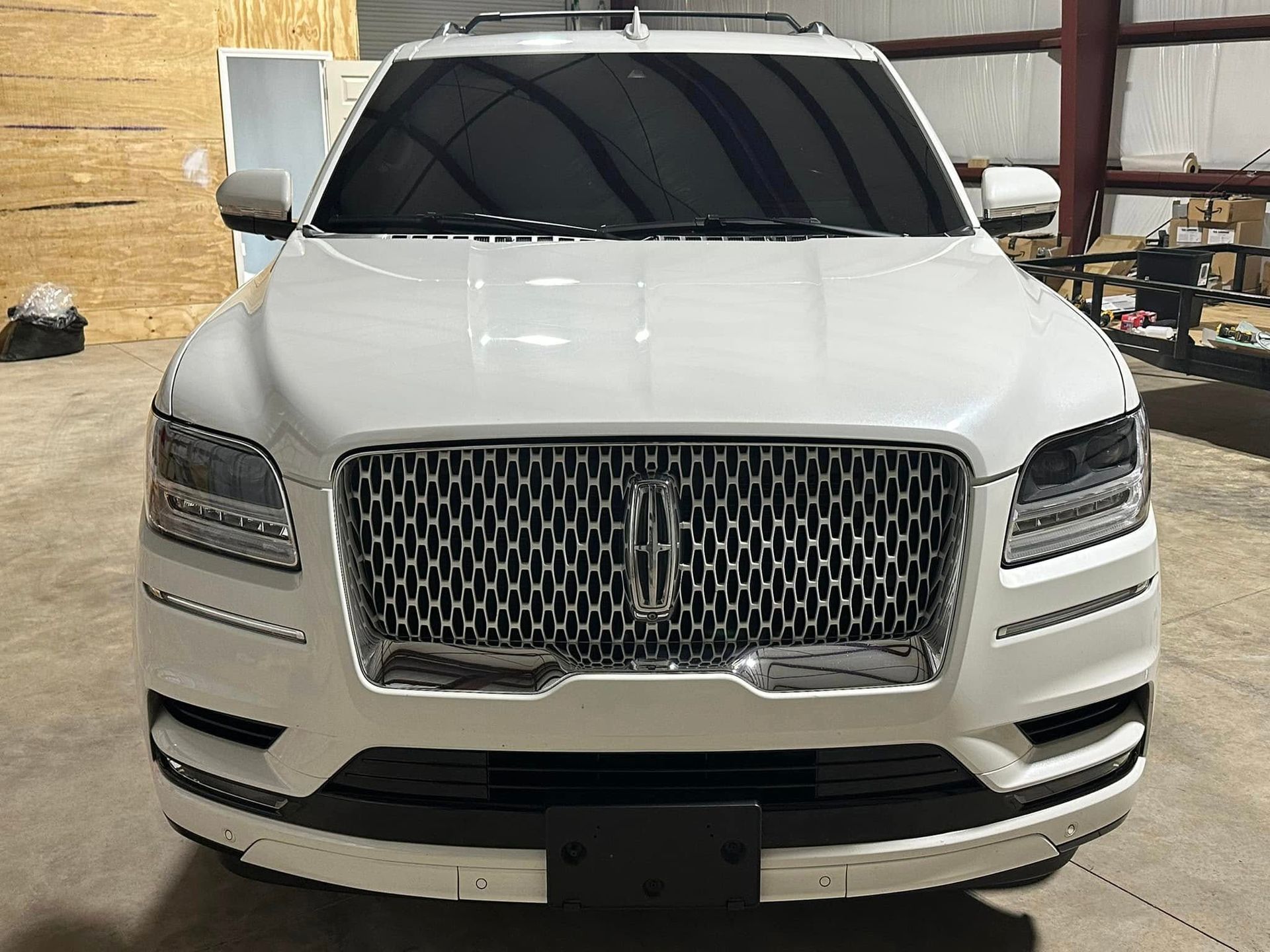 A white lincoln continental is parked in a garage.