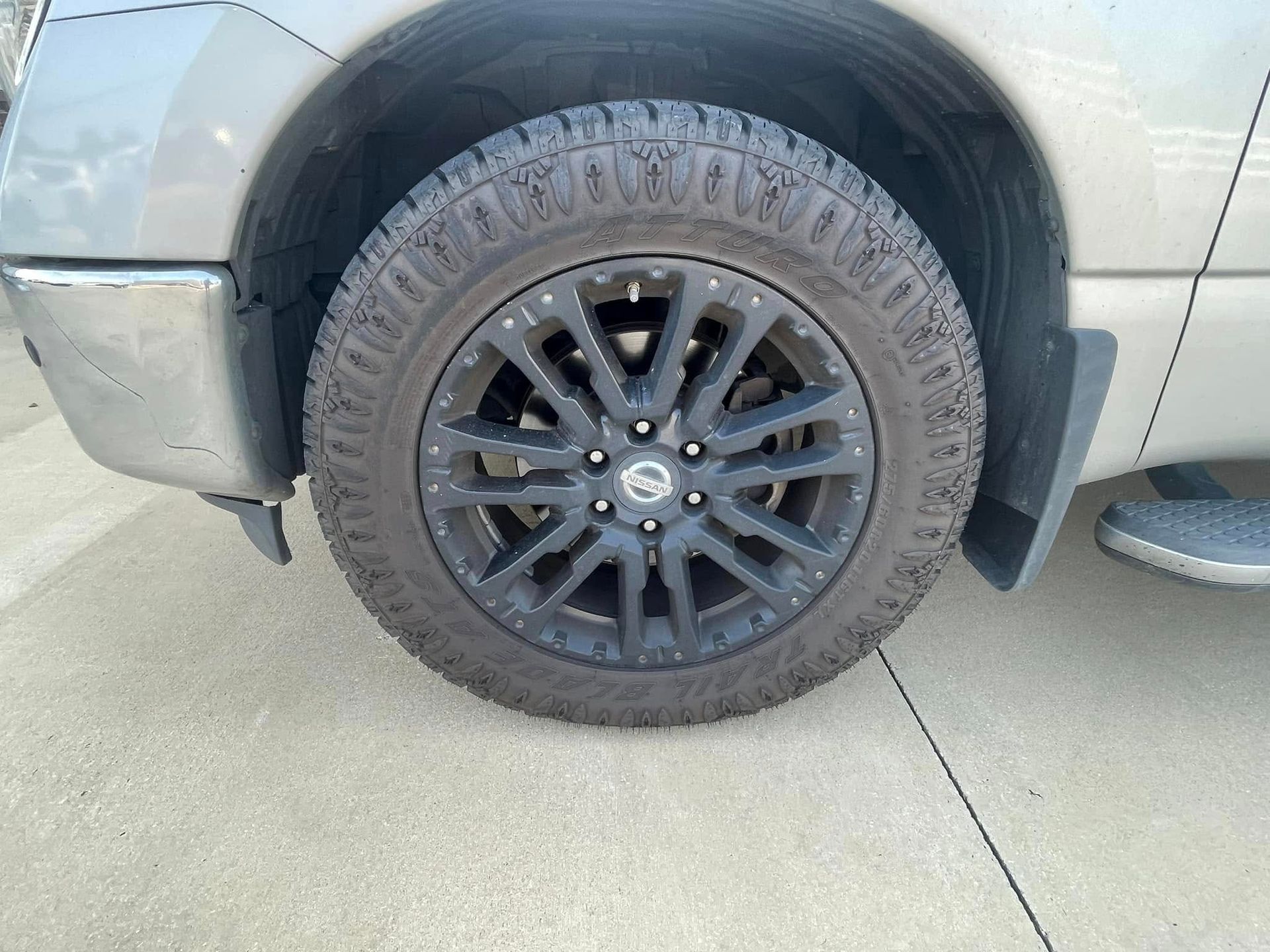 A close up of a truck tire on a concrete surface.