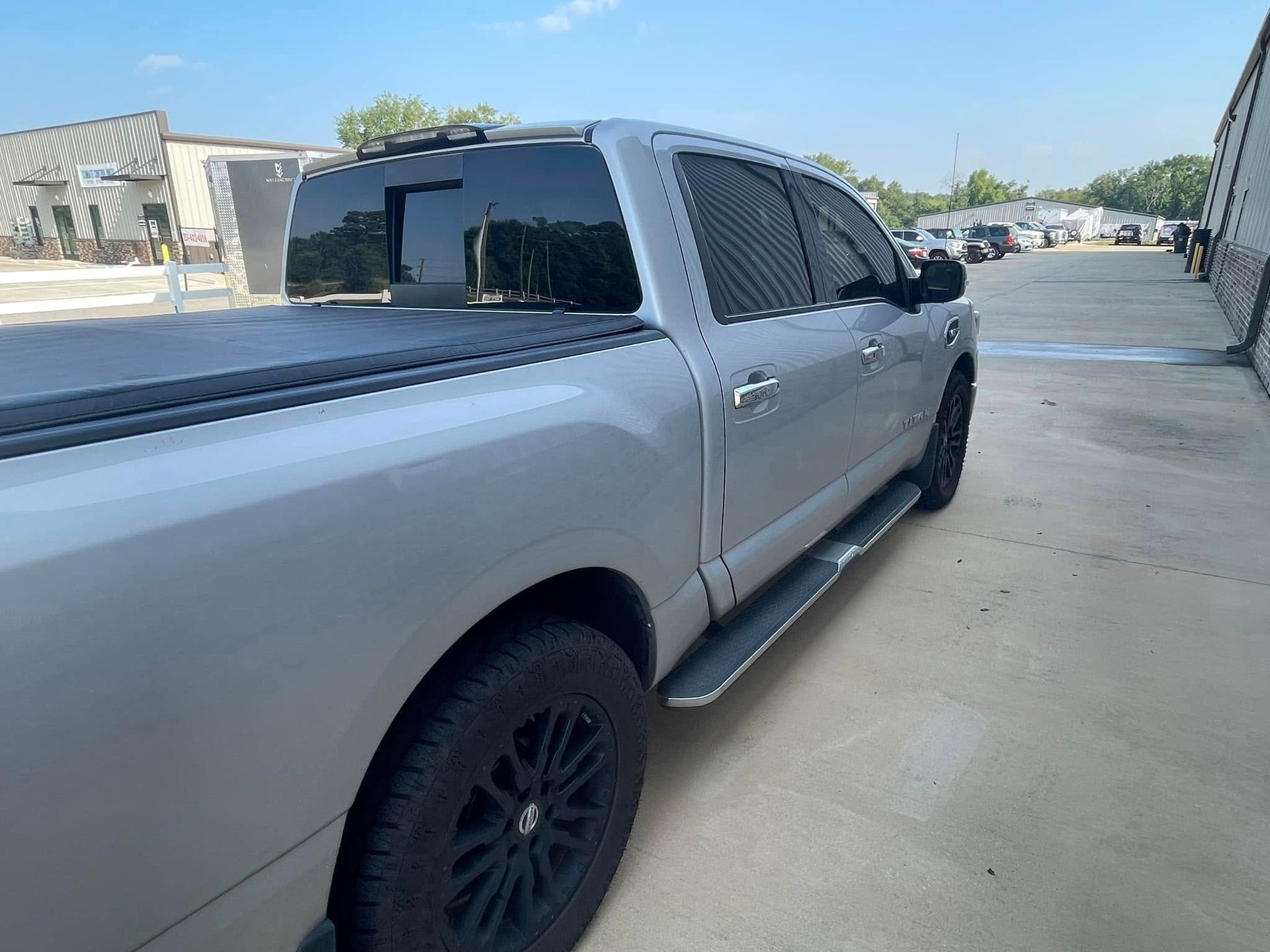 A silver truck is parked in a parking lot.