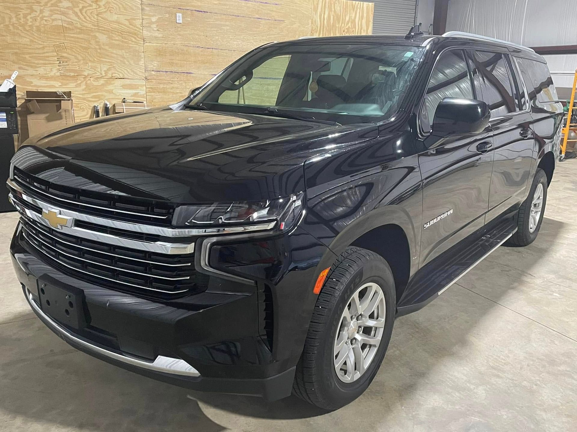 A black chevrolet suburban suv is parked in a garage.