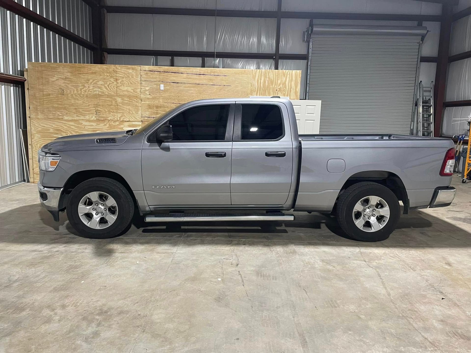 A silver dodge ram truck is parked in a garage.
