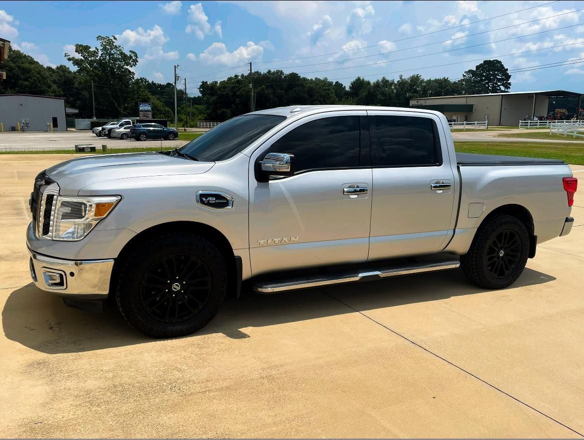 A silver truck is parked in a parking lot on a sunny day.