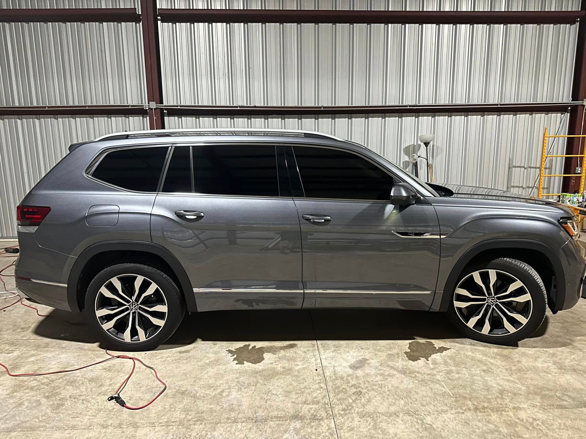 A gray suv is parked in front of a building.