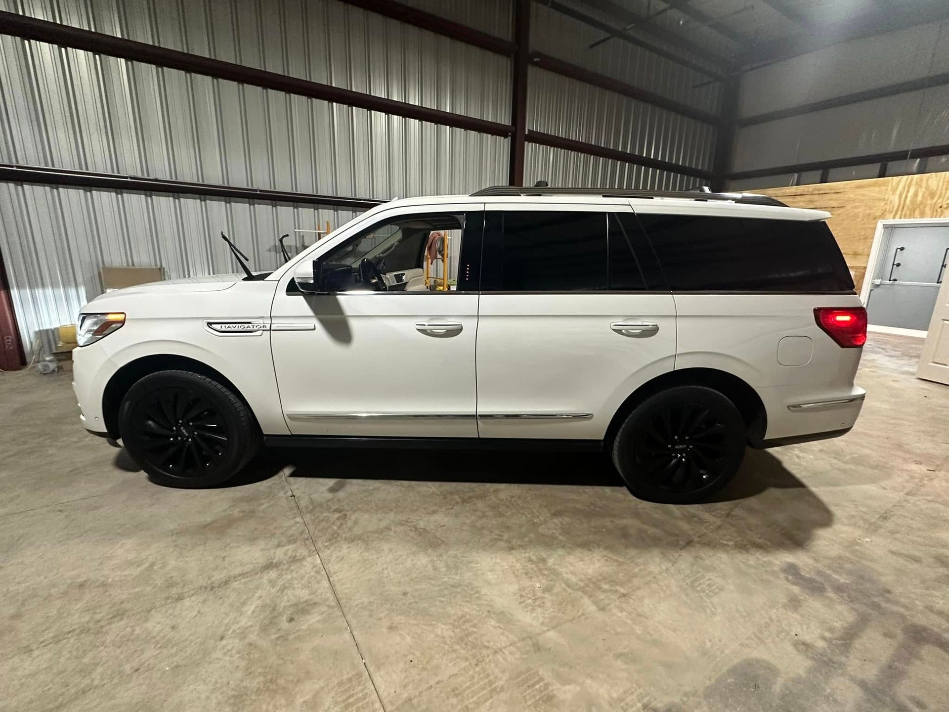 A white ford expedition is parked in a warehouse.