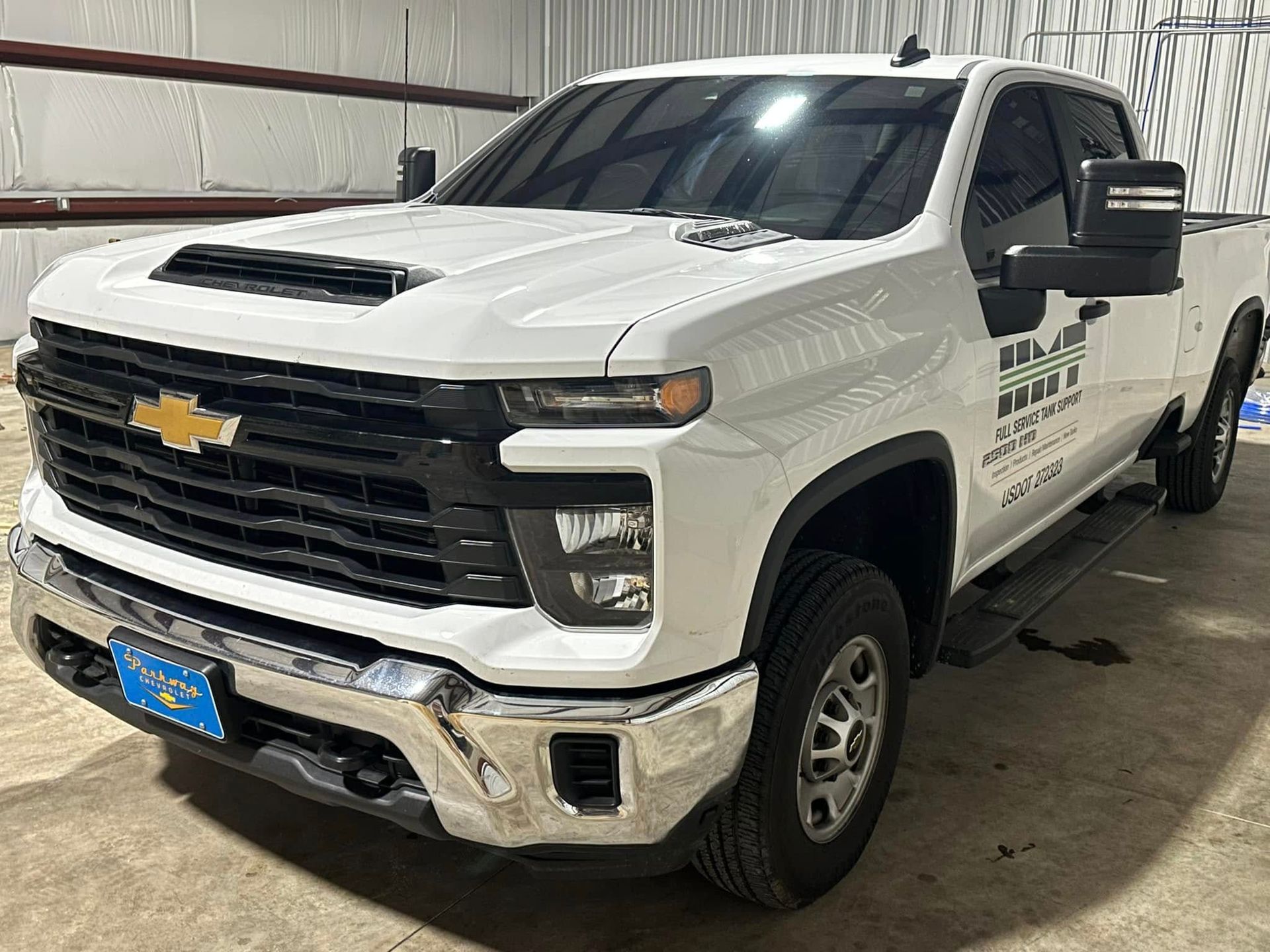 A white truck is parked in front of a building.