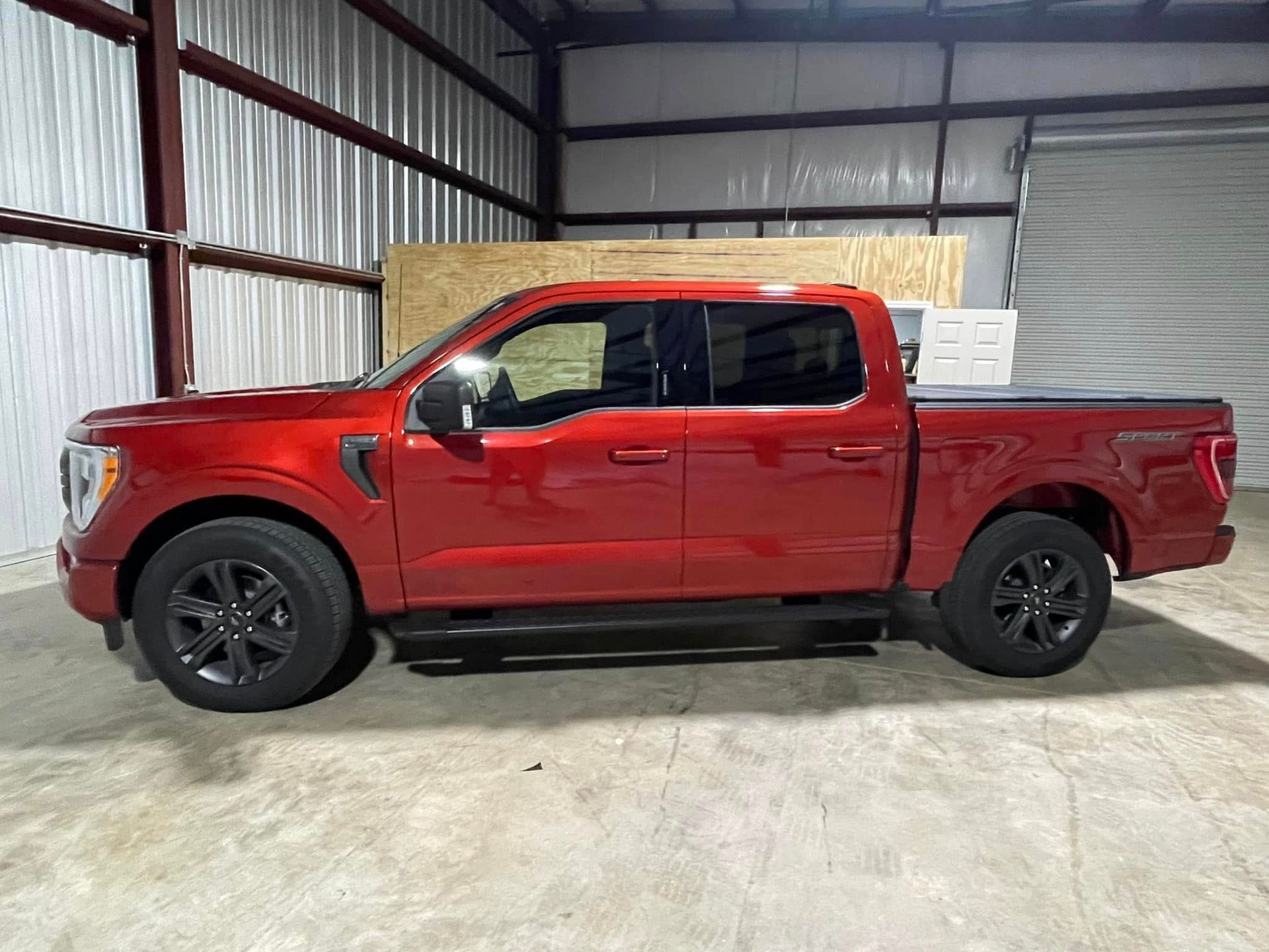 A red pickup truck is parked in a garage.