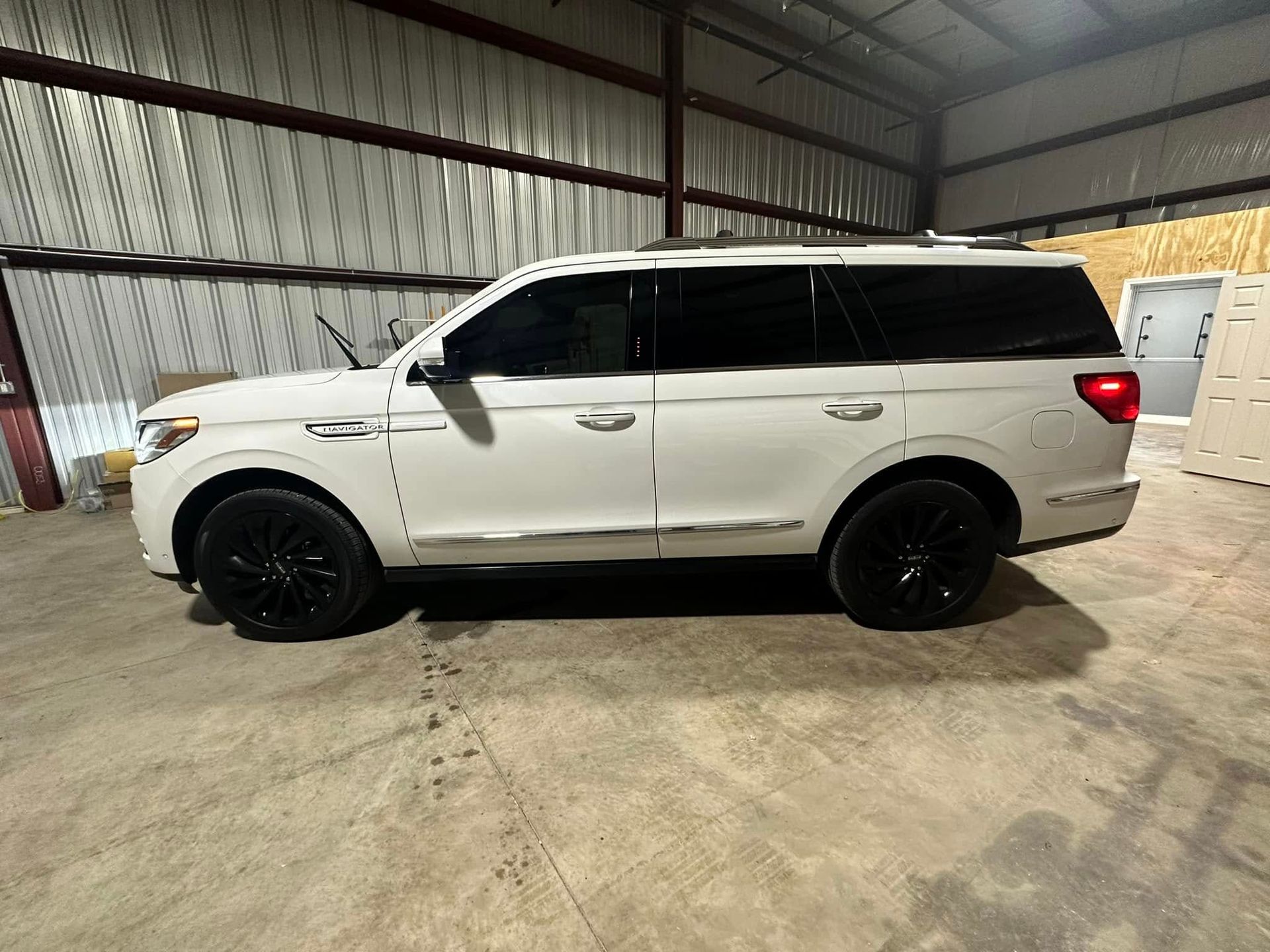 A white ford expedition is parked in a warehouse.
