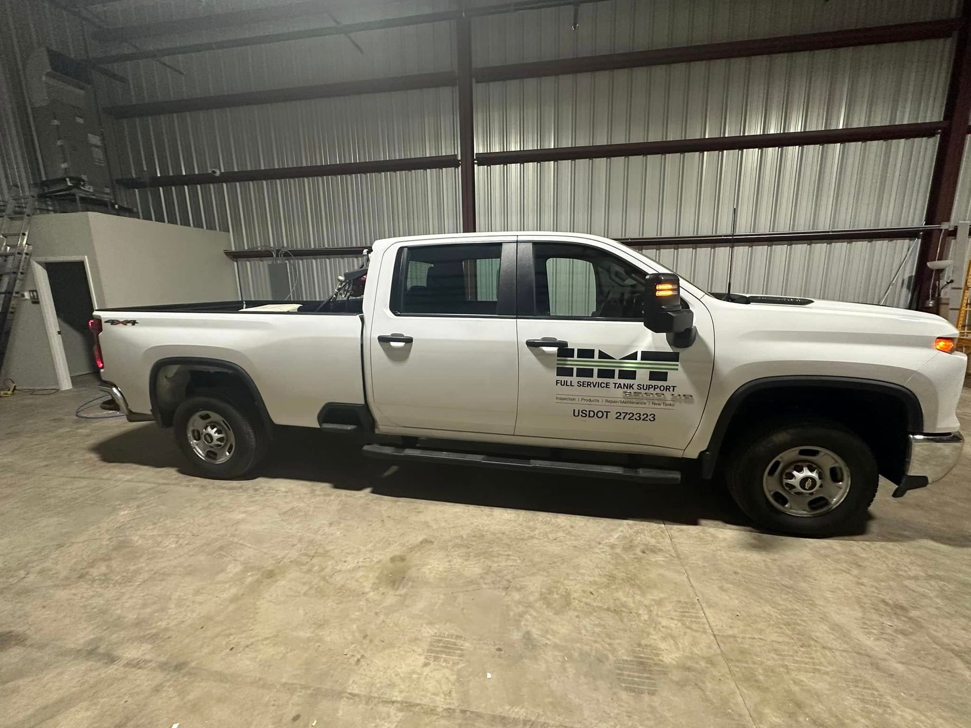 A white truck is parked in a warehouse.