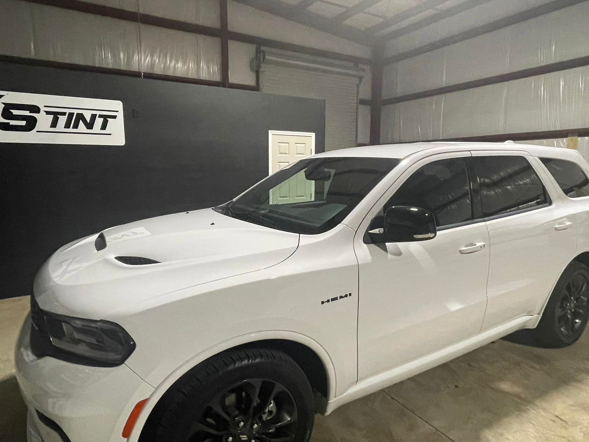 A white dodge durango is parked in a garage.