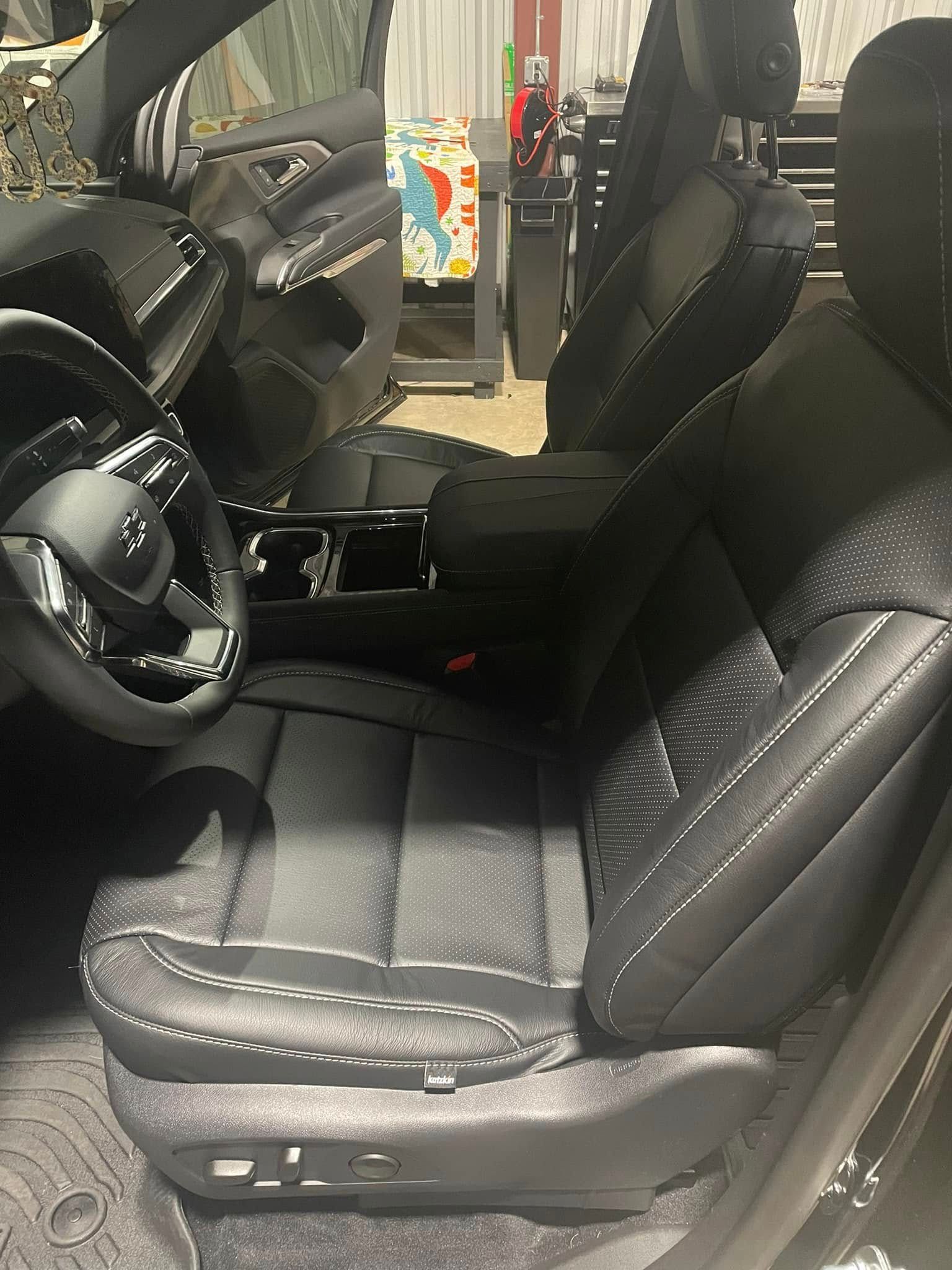 The interior of a car with black leather seats and a steering wheel.