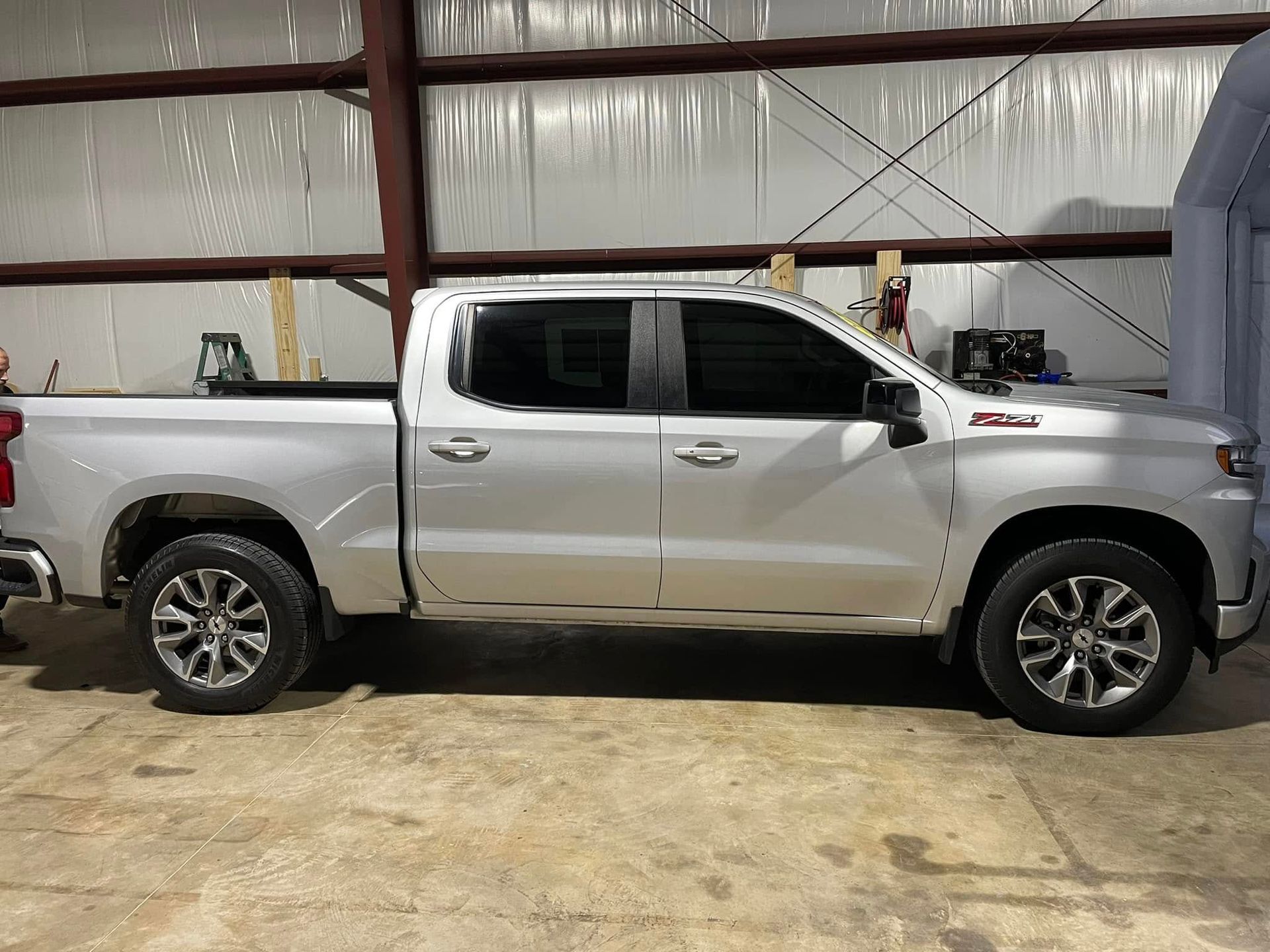 A silver pickup truck is parked in a garage.