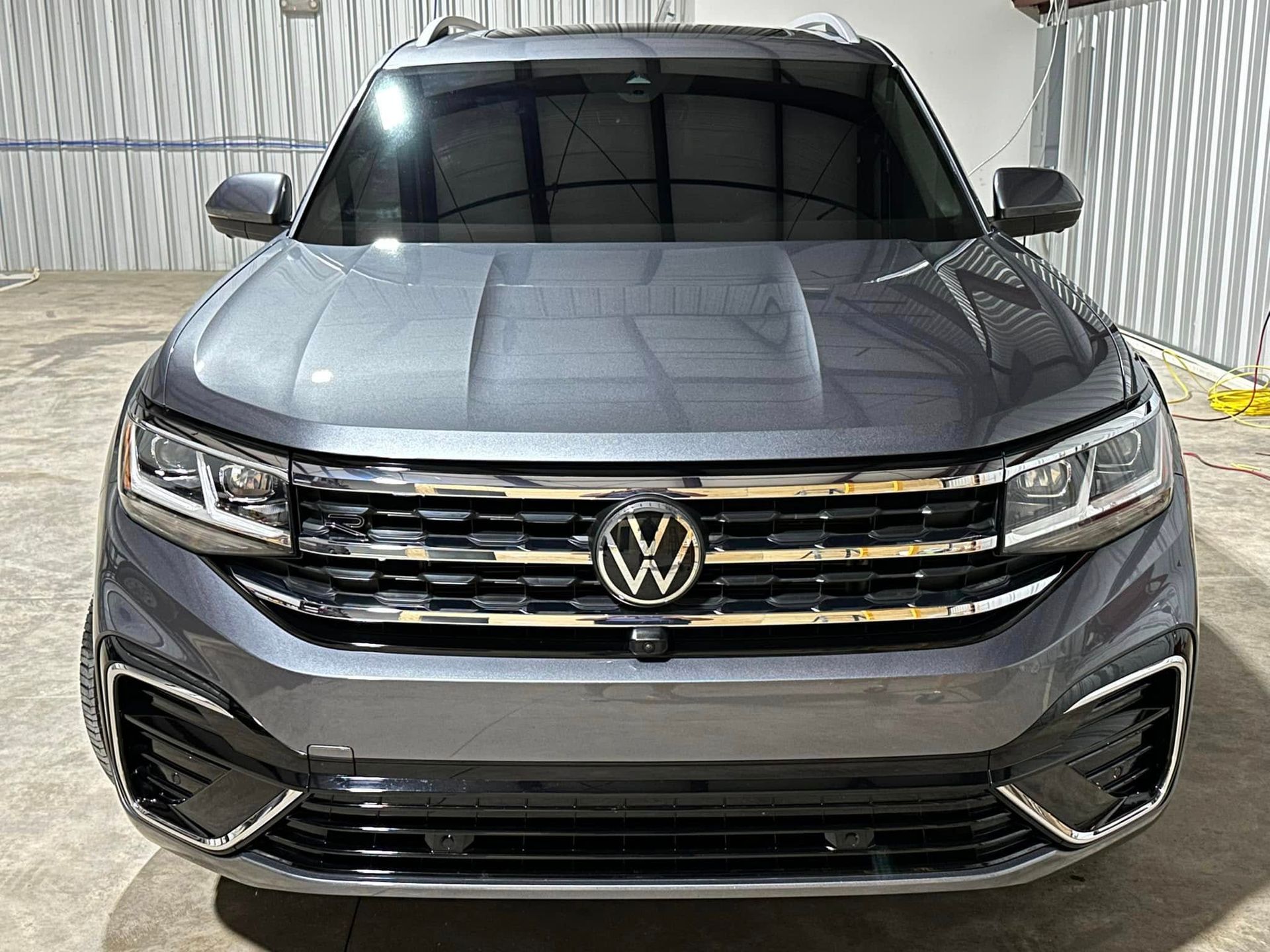 The front of a volkswagen atlas is parked in a garage.