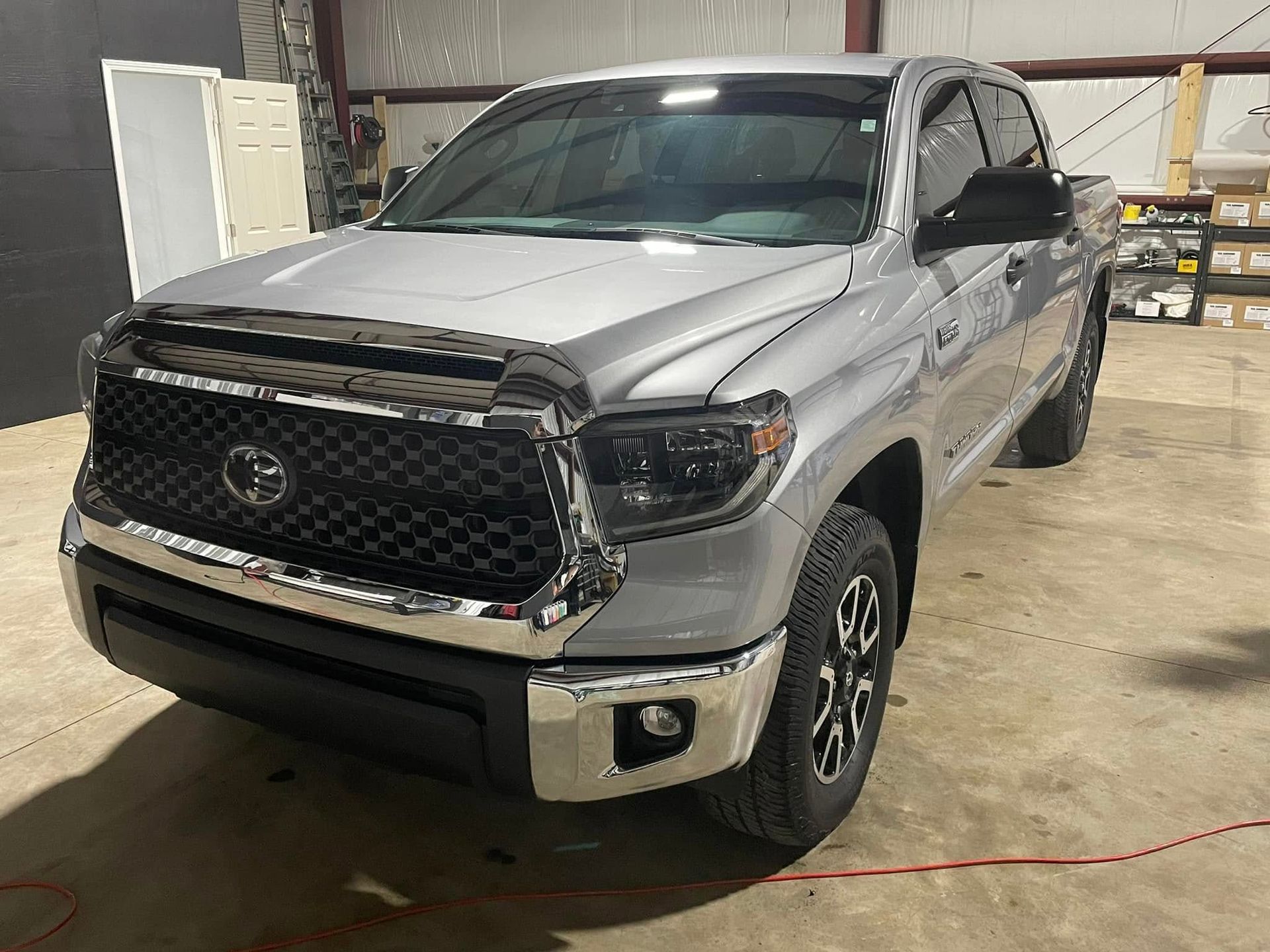A silver toyota tundra is parked in a garage.