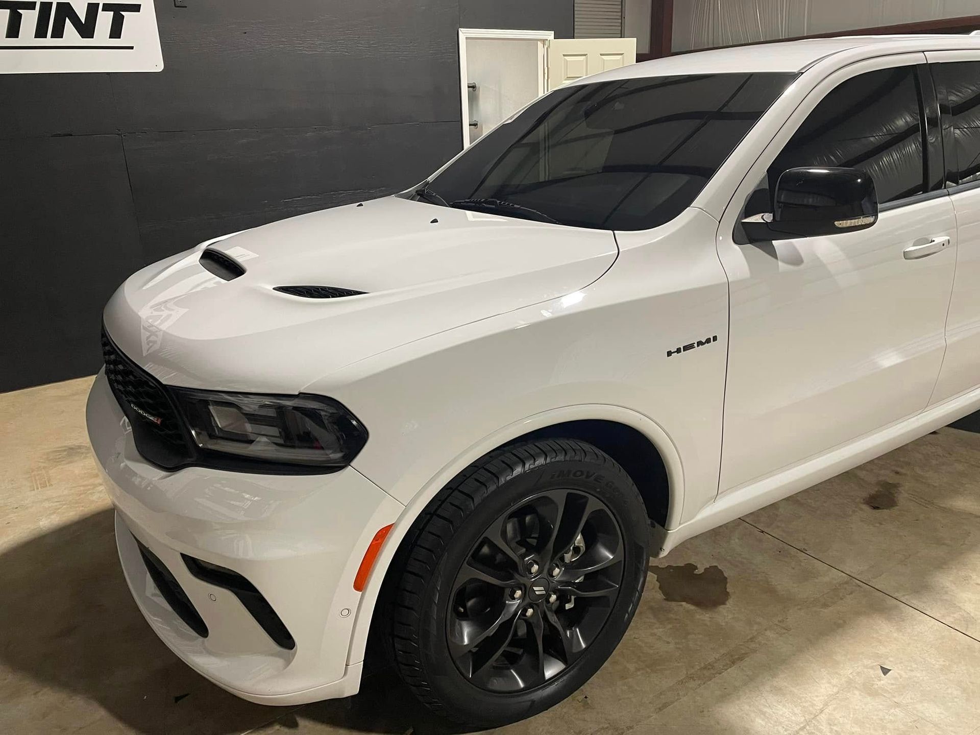A white dodge durango is parked in a garage.
