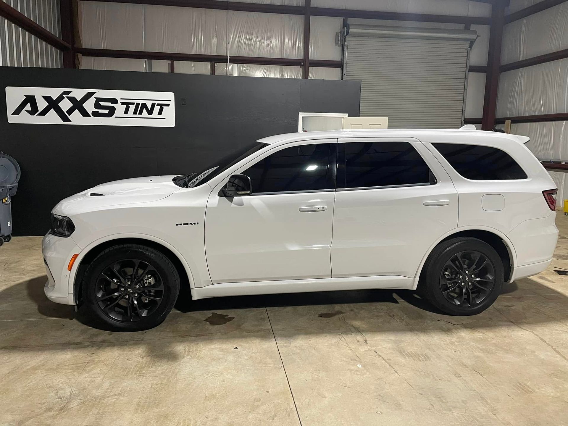 A white dodge durango is parked in a garage.