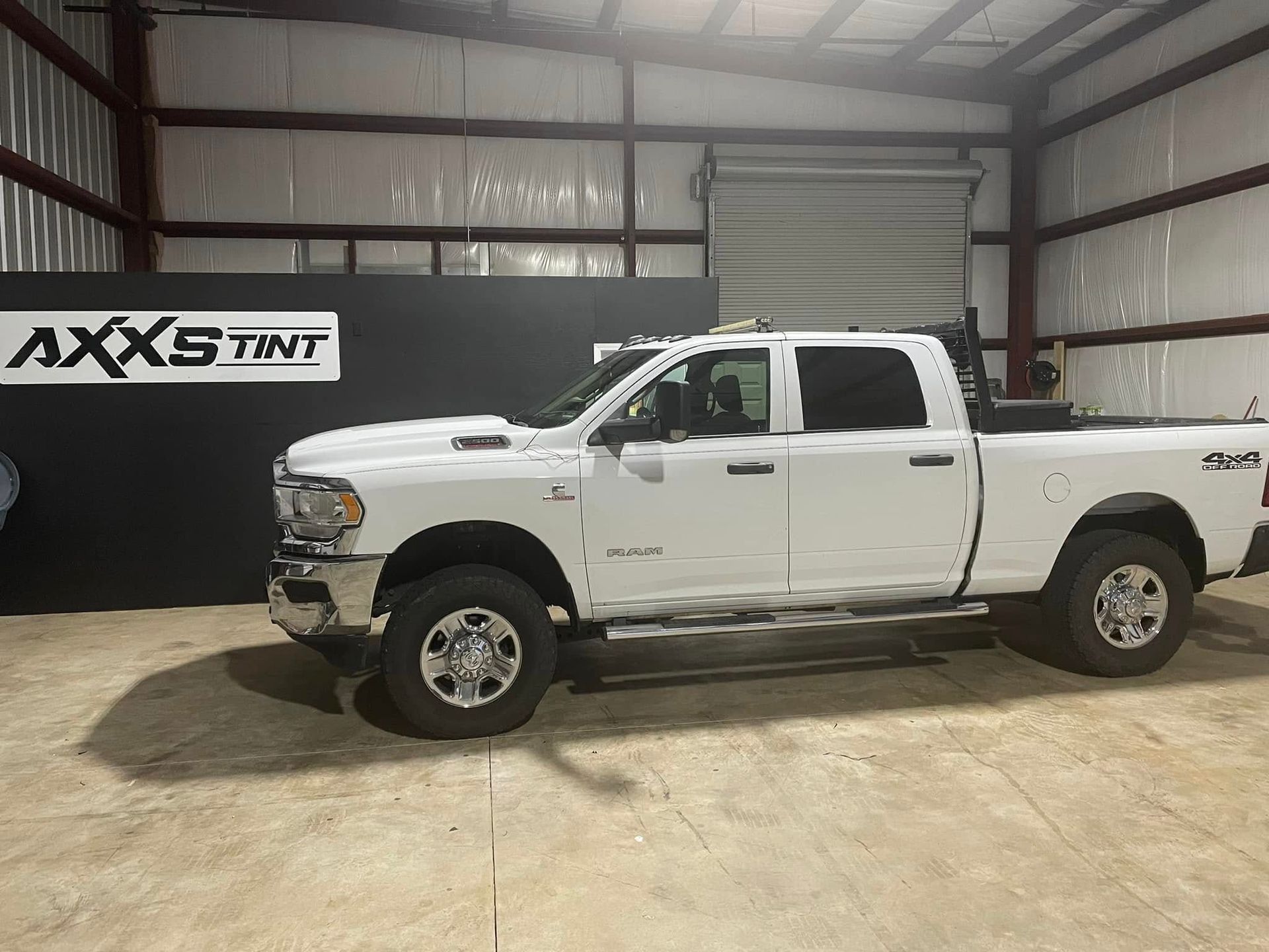 A white pickup truck is parked in a warehouse.